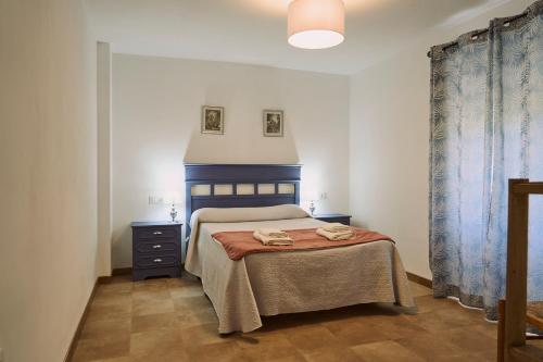 a bedroom with a bed and a table with towels on it at Casilla Soleá Rural in Carcabuey