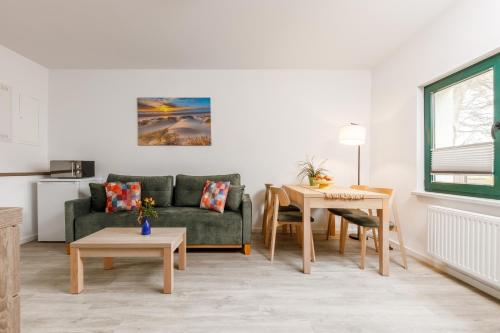 a living room with a couch and a table at Feriendorf Strandgut in Altenkirchen