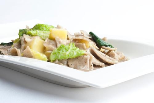 a white plate of food with broccoli and meat at Hotel Mirella in Ponte di Legno