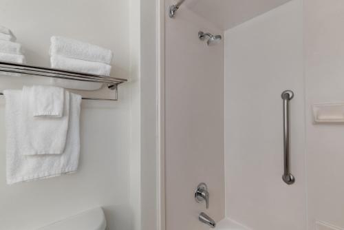 a bathroom with a shower and white towels at Garner Hotel Murfreesboro West by IHG in Murfreesboro