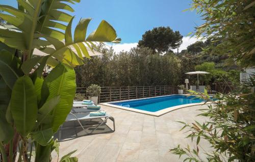 a swimming pool in a garden with a table and a chair at Corazon in Canyamel