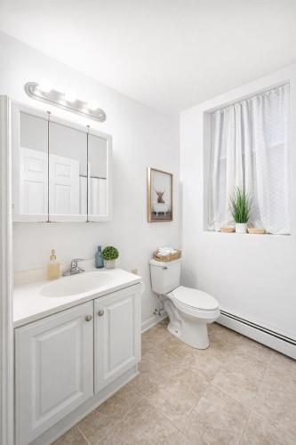 a white bathroom with a toilet and a sink at Cozy up with me! Longer stays! Free parking in Troy