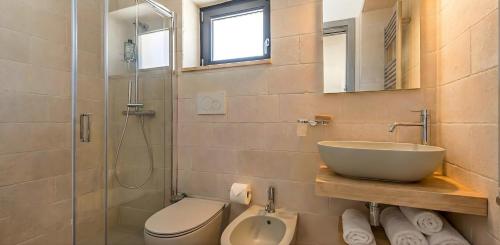 a bathroom with a sink and a toilet and a shower at Stefano's Villa in Cisternino