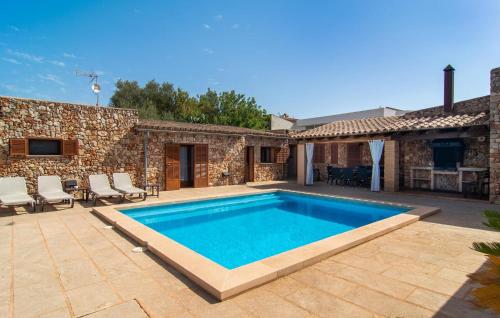 a swimming pool in front of a stone house at S'hortet in Campos