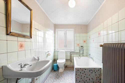a bathroom with a sink and a tub and a toilet at FY406-Faaborg-Bojestraede-4-A in Faaborg