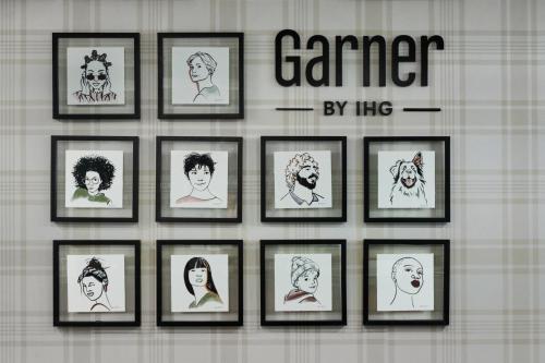 a group of drawings of people in frames on a wall at Garner Hotel Murfreesboro West by IHG in Murfreesboro