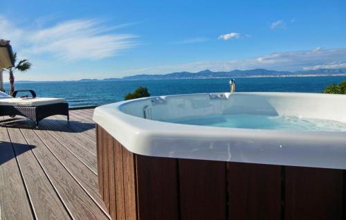 a bath tub sitting on a deck next to the ocean at Robert Christopher Börner in Badia Gran