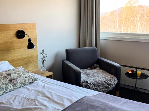 a bedroom with a chair and a bed and a window at Sirdal Høyfjellshotell in Fidjeland
