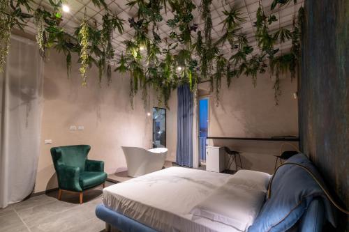a bedroom with a bed and a green chair at Sonrisa Suites in Taranto