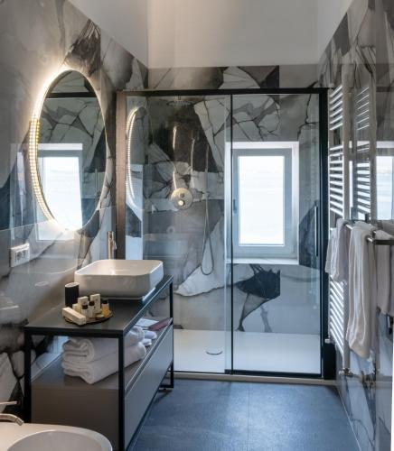 a bathroom with a glass shower and a sink at Sonrisa Suites in Taranto