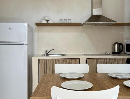 a kitchen with a table and chairs and a refrigerator at SĀN Living in Golem