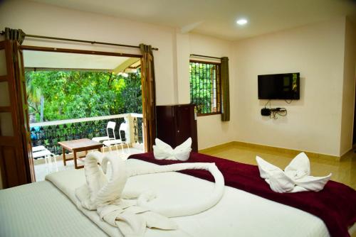 a bedroom with two beds with white towels at Wayne Nest Calangute in Calangute