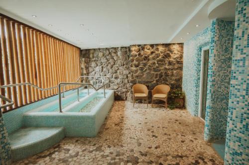 a bathroom with a bath tub and two chairs at Grand Hotel Il Moresco in Ischia Town