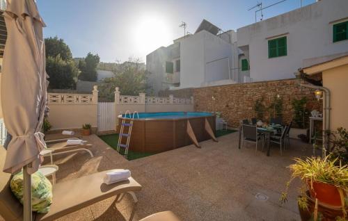 a patio with a table and a pool in a backyard at Casa Hermosa in Capdepera