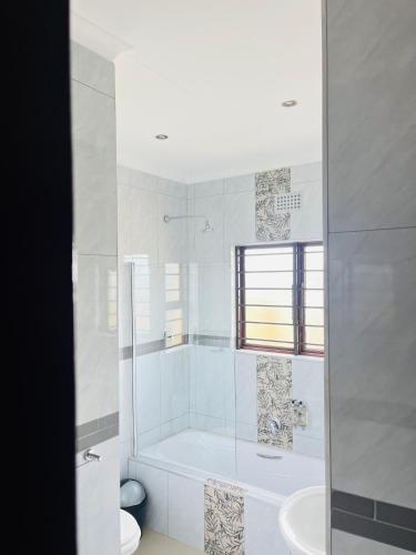 a white bathroom with a tub and a sink at Langelihle- Margate Accommodation in Margate