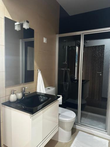 a bathroom with a black sink and a toilet at Casa do Pessegueiro in Mirandela