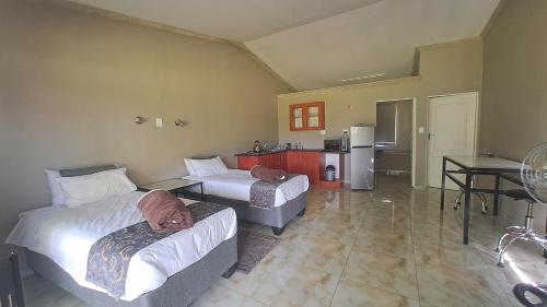 a hotel room with two beds and a kitchen at The Spot at Ghanzi in Khemsbok