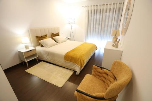 a small bedroom with a bed and a chair at Casa do Pessegueiro in Mirandela