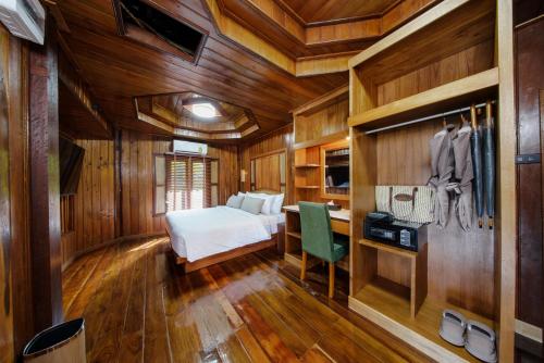 a bedroom with wooden walls and a bed and a desk at Calisto Valley I Luxury Pool Villa Krabi in Ao Nam Mao