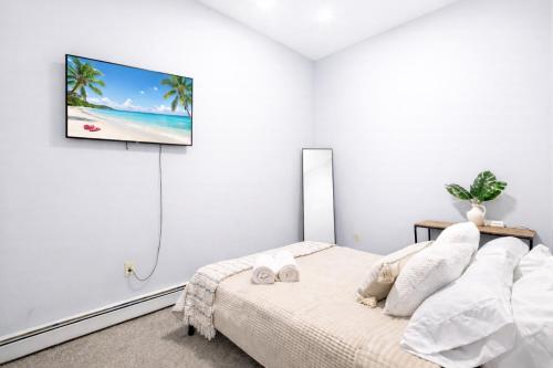 a bedroom with a bed and a tv on the wall at Escape your everyday in your COZY HIDEAWAY Feel right at home Relax recharge & unwind in Troy