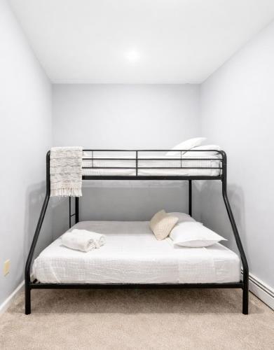 a black bunk bed in a white room at Escape your everyday in your COZY HIDEAWAY Feel right at home Relax recharge & unwind in Troy