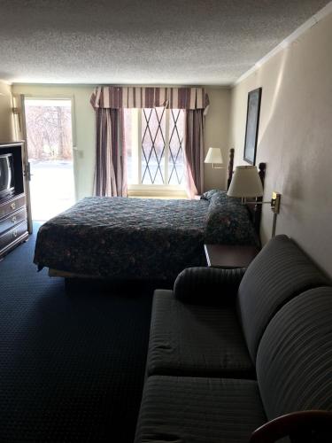 a hotel room with a bed and a couch at Home Town Inn in Flint