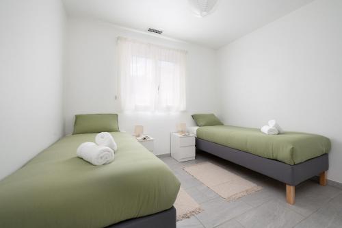a bedroom with two beds with white towels on them at Évasion à Bruguières in Bruguières