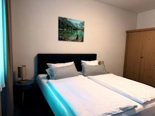 a bedroom with a bed with white sheets at Gasthof Hotel Bräustübl und Haus Boutique in Selb