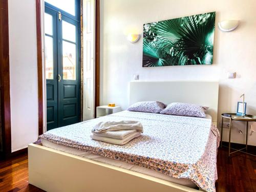 a bedroom with a bed and a green door at Guest House Sir Manuel - Unidade São Vicente in Braga