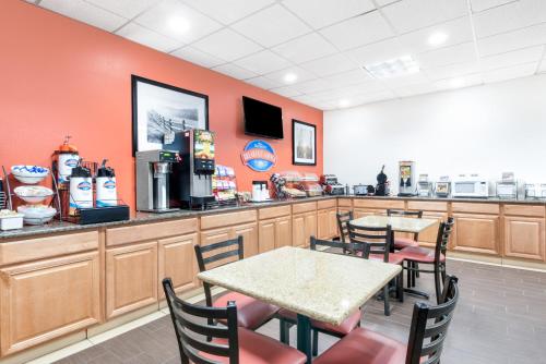 a fast food restaurant with two tables and a counter at Baymont by Wyndham Midland Airport in Midland
