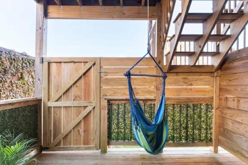 a hammock hanging in a room with a fence at Jennifer's Modern Federal Hill Apt w Private Deck in Providence