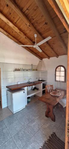 a kitchen with a table and a wooden ceiling at Cabañas Cerro Colonial in Trapiche