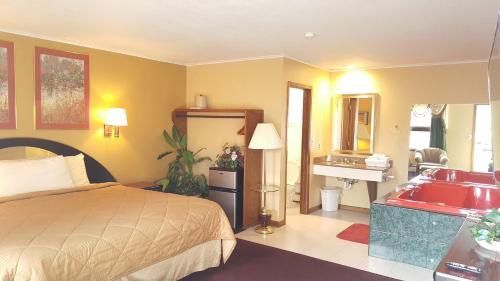 a bedroom with a bed and a bathroom with a sink at Oakdale Motel in Owatonna