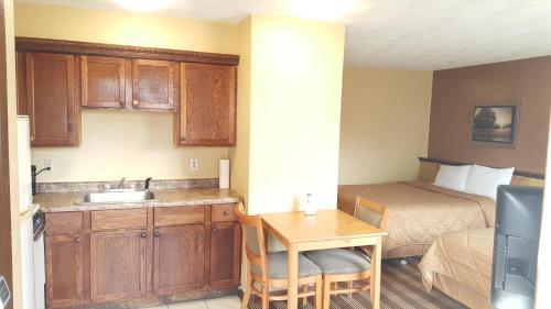 Habitación pequeña con cocina, cama y lavabo. en Oakdale Motel, en Owatonna