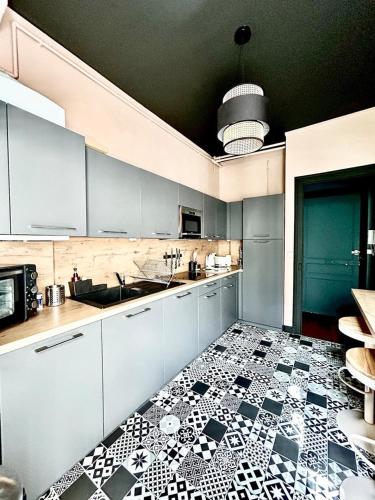 a kitchen with a black and white tile floor at Appartement ATHOS - Hyper Centre - Familiale in Orléans
