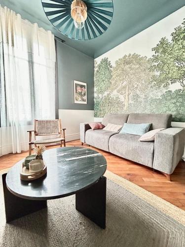 a living room with a couch and a table at Appartement ATHOS - Hyper Centre - Familiale in Orléans