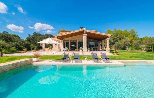 a swimming pool with chairs and a house at Golf Marina in Pollença