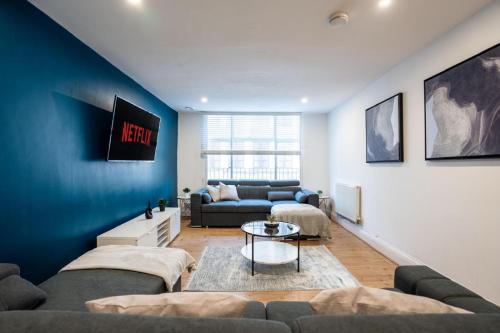 a living room with a couch and a table at Stylish Modern Apartment in the heart of the city in Manchester