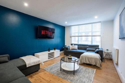 a living room with a couch and a table at Stylish Modern Apartment in the heart of the city in Manchester