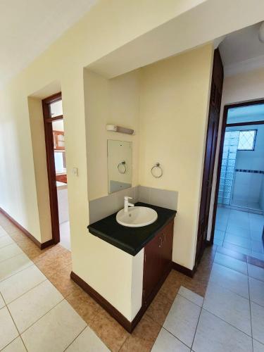 a bathroom with a sink and a mirror at MoDi's Seaside Nest in Mombasa