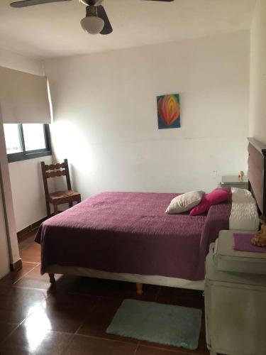 a bedroom with a purple bed and a chair at Casa- alojamiento Gerez in San Antonio de Arredondo