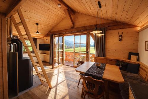 a dining room with a table and a large window at Chalet Herbst in Lofer