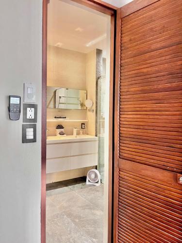 a bathroom with a sink and a wooden door at The Mermaid and The Pearl Boutique Hotel in Isla Mujeres