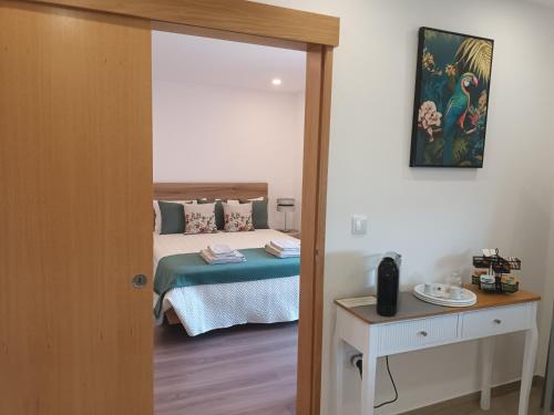 a bedroom with a bed and a table and a mirror at Panorama Douro House in Armamar