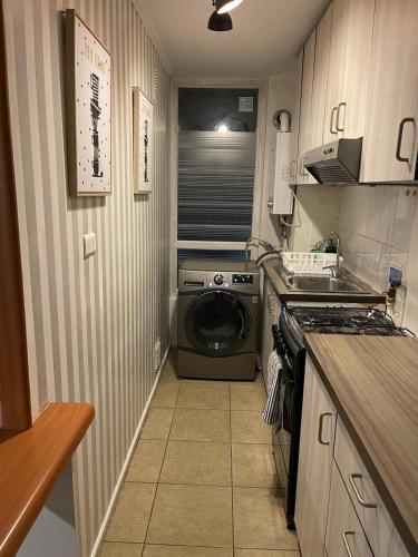 a small kitchen with a washing machine in the corner at Departamento outlet Puerto Montt con estacionamiento in Puerto Montt