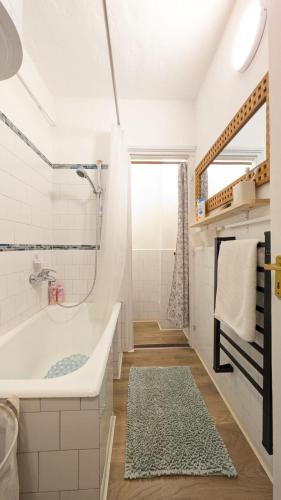 a white bathroom with a tub and a shower at Gesztenyés Backpackers in Kőszeg