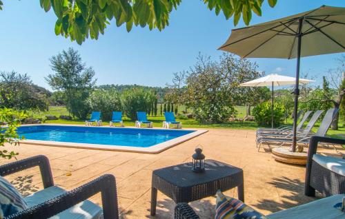 a swimming pool with chairs and an umbrella at Can Sua in Artá