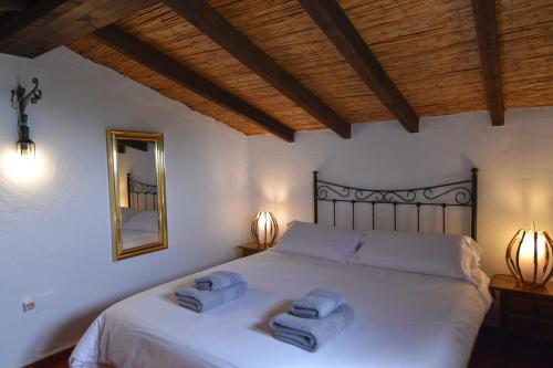 a bedroom with a white bed with two towels on it at Finca La Sierra with private Pool in Cómpeta