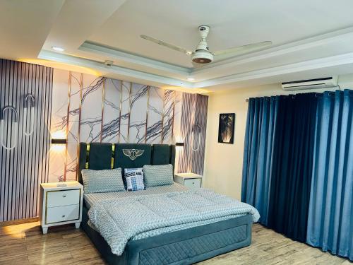 a bedroom with a blue bed and blue curtains at Modern City Escape Bahria hieghts in Rawalpindi