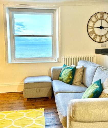 a living room with a couch and a window at Central, Seaview Apartment, 3 beds, 2 baths, kid & dog friendly at The Lookout Broadstairs in Broadstairs